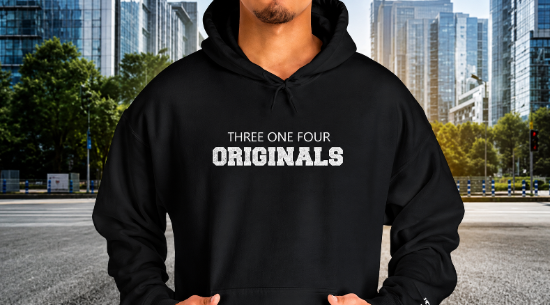 A man wearing a black pullover hoodie with the text 'THREE ONE FOUR ORIGINALS' printed in white on the chest, set against a blurred city street background.